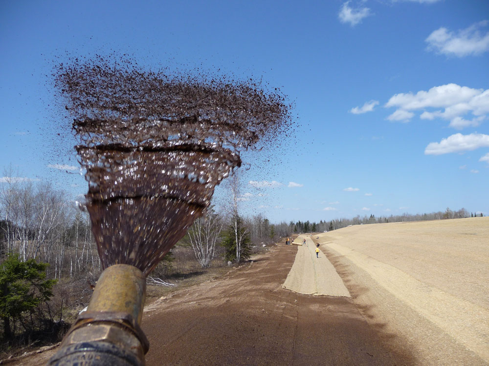 Spraying Biotic Earth biotic soil amendment