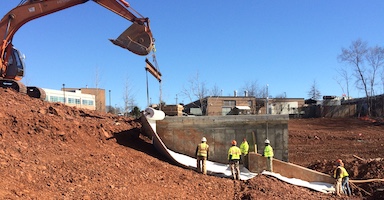 Construction equipment lifts clay liner