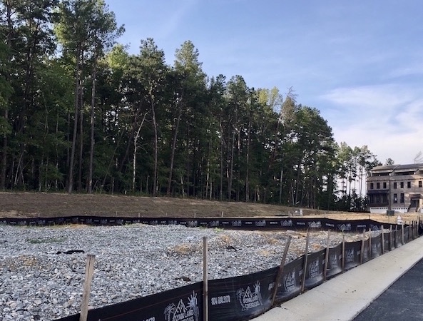Logo silt fence surrounds residential construction project