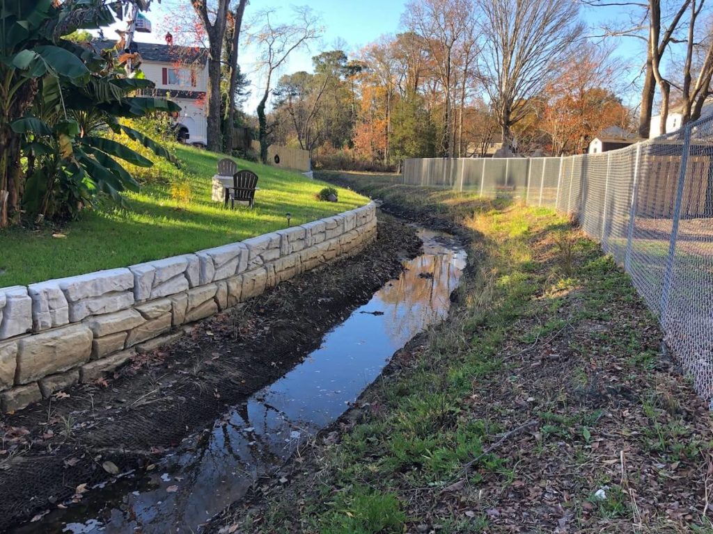 Stream channel reinforced with MSE retaining wall